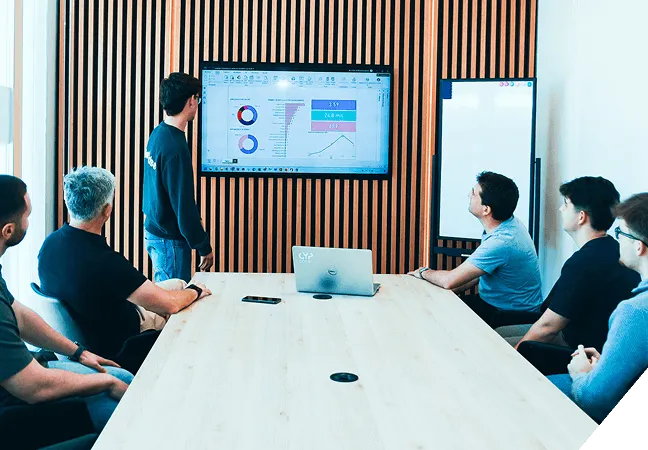 Consultores IA reunidos analizando datos en pantallas